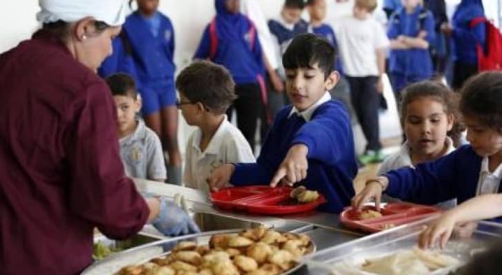 طفال يتسلمون وجبة في مدرسة 