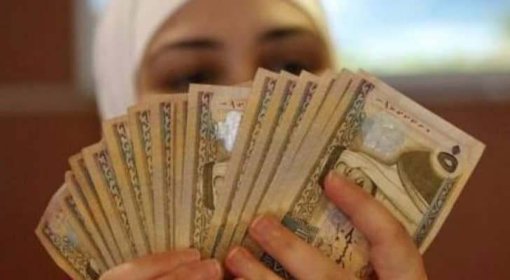 موظفة تعد أوراق نقد من الدينار الأردني
