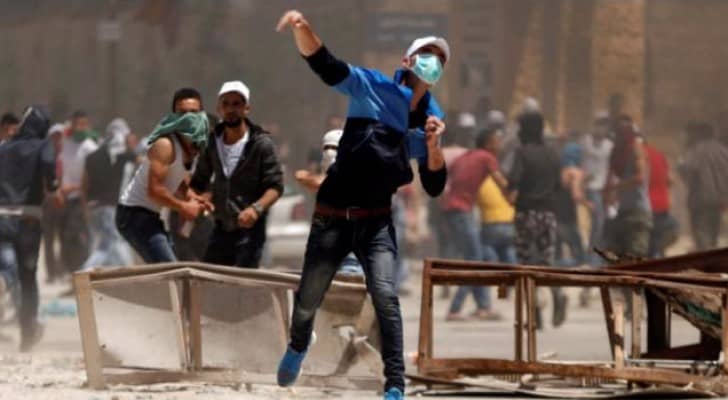 شاب فلسطيني يرشق قوات الاحتلال بالحجارة خلال تظاهرة لمناصرة الأسرى قرب نابلس .
