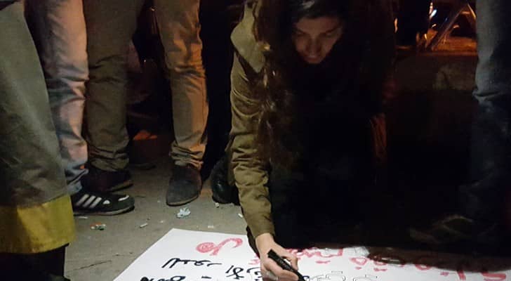عشرينية تخط رسائلها على الملصقات دفاعا عن القدس
