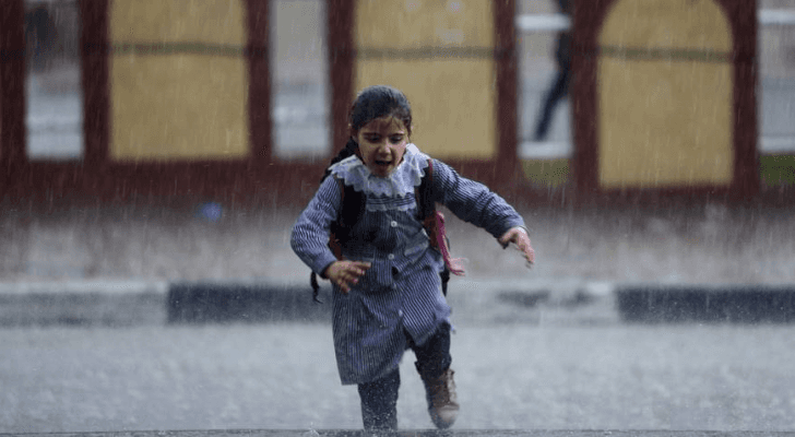 طفلة تحت غزارة الامطار - ارشيفية