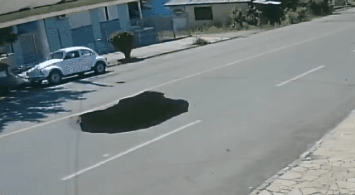 حفرة تظهر فجأه وسط الطريق وتبتلع سيارة في البرازيل..فيديو