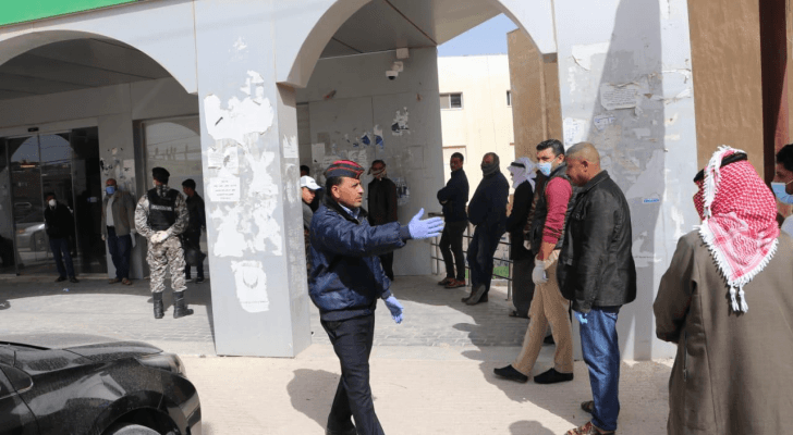 رجال الامن العام ينظمون الاصطفاف والدور أمام فروع البنوك