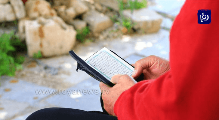 رجل يقرأ القرآن الكريم في وسط البلد