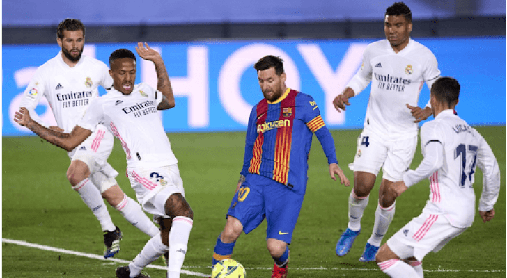 ليونيل ميسي يسيطر على الكرة وسط عدد من لاعبي ريال مدريد - أرشيفية