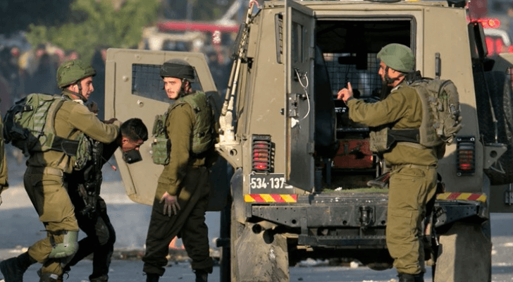 جنود من جيش الاحتلال الإسرائيلي يعتقلون فلسطينيا