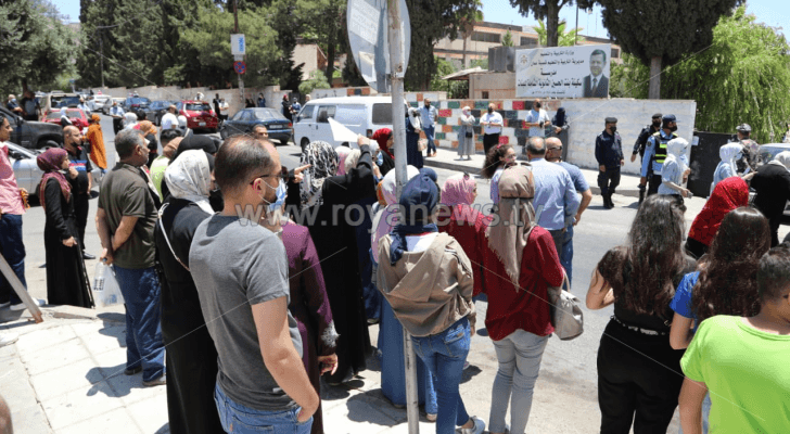 طلبة التوجيهي والأهالي امام أحد المدارس في العاصمة عمان
