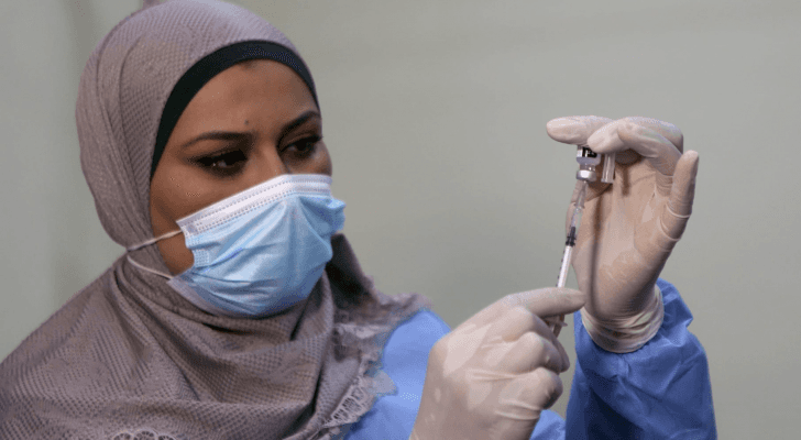 مكعوم كورونا خلال إعطاءه لأحد المتلقين - أرشيفية