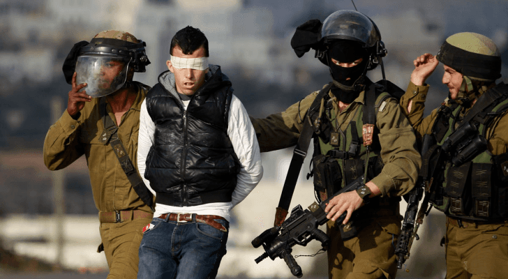 عناصر من قوات الاحتلال الإسرائيلي تعتقل شابا فلسطينيا - أرشيفية