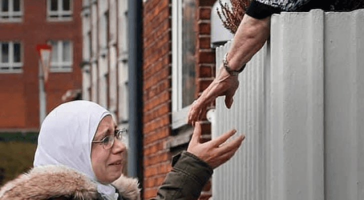 لاجئة سورية تبكي مادة يدها لجارتها في مشهد يفطر القلب