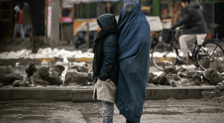 أفغانية تتسول مع طفلة في أحد شوارع كابول- ا ف ب/ارشيف