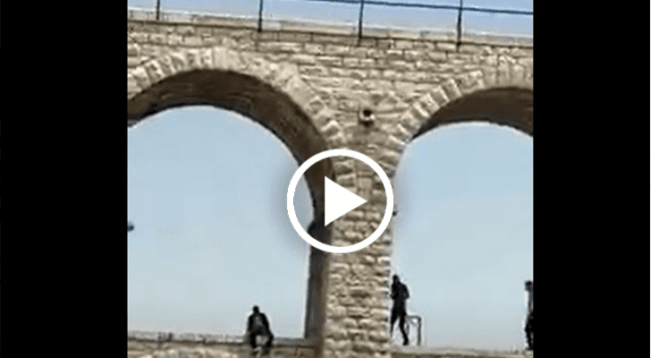 رجلا أمن يمنعان شخصا هدد بإلقاء نفسه من أعلى الجسور العشرة