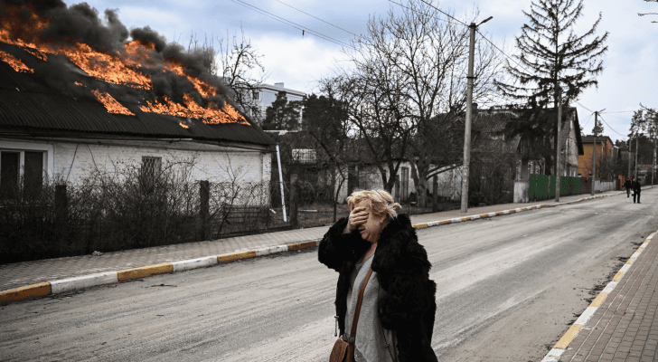 سيدة أوكرانية تقف أمام منزل تعرض لقصف روسي