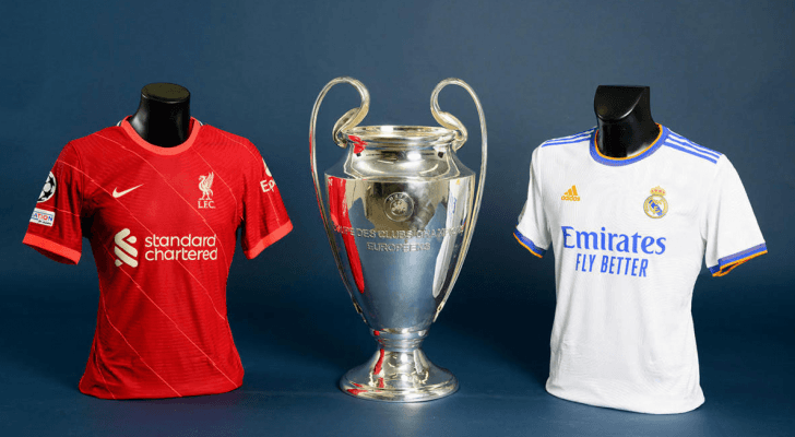 صورة تعبيرية لقميصي ريال مدريد وليفربول بينهما كأس بطولة دوري أبطال أوروبا