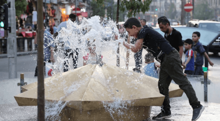 طفل يلهو بالماء وسط العاصمة عمان