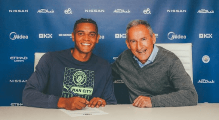 المدافع الدولي السويسري مانويل أكانجي (يسار) في أثناء توقيعه على عقد انتقاله إلى مانشستر سيتي