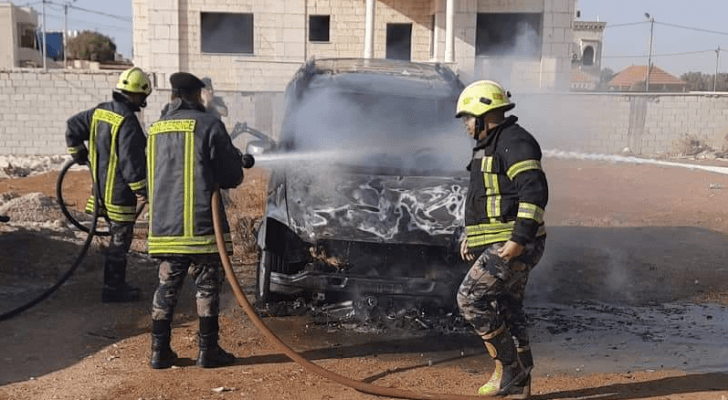 كوادر الدفاع المدني أثناء إخماد حريق المركبة