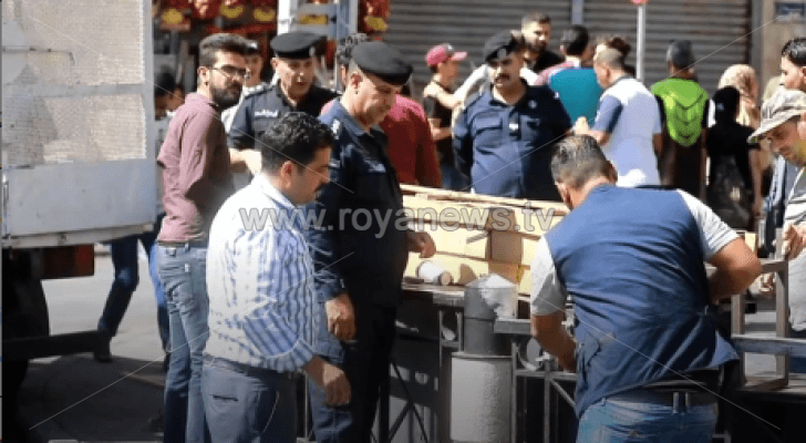 رجال أمن أثناء إزالتهم إحدى البسطات العشوائية في وسط البلد