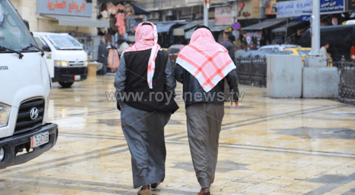 رجلان يسيران وسط العاصمة عمان