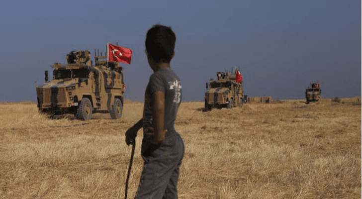 طفل يقف ينظر إلى القوات التركية