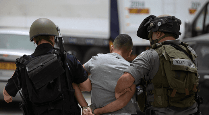 صورة أرشيفية لعنصرين في قوات الاحتلال يعتقلان شابا فلسطينيا