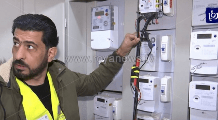 شخص أمام عدادات الكهرباء