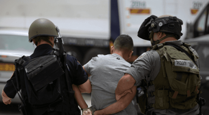 صورة أرشيفية لعنصرين في قوات الاحتلال يعتقلان شابا فلسطينيا