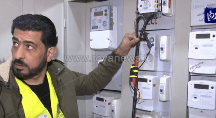 شخص يقف أمام عدادات الكهرباء