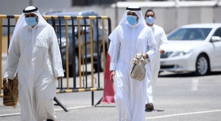 أشخاص يرتدون الكمامة في الطريق العام