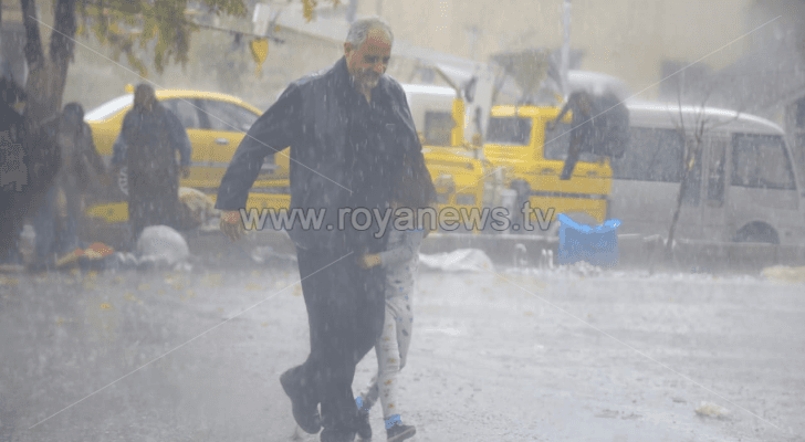 رجل يسير في أجواء ماطرة - ارشيفية