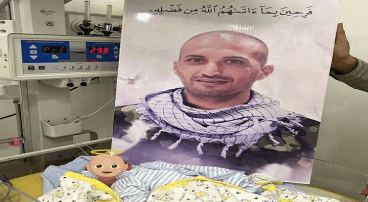 صورة الشهيد محمد صبح أمام طفله "محمود"