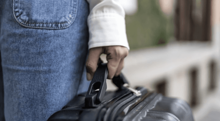 سيدة تحمل حقيبة سفر "تعبيرية"