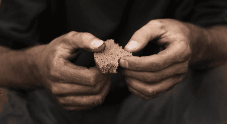 شخص يحمل قطعة خبر