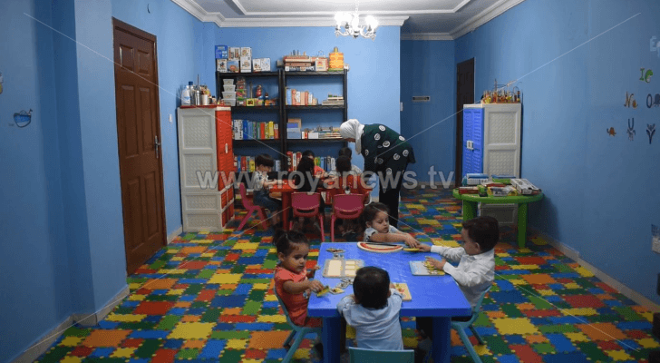 السيدة نجوى وهي تعلم الأطفال