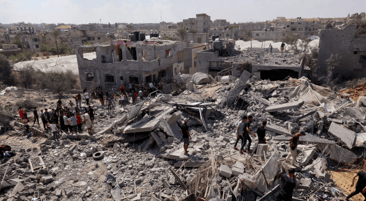 غزيون على أنقاض المباني المدمرة في القطاع بعد ضربة قوات الاحتلال