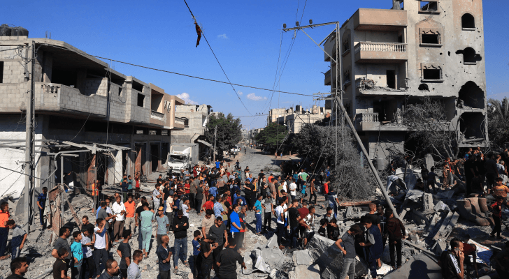 لفلسطينيون يتجمعون على موقع المباني المنهارة والمتضررة جراء غارات الاحتلال التي استهدفت رفح