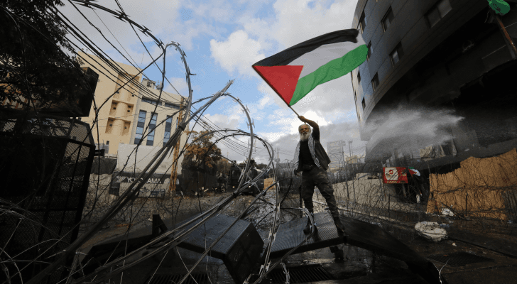 لبناني يحمل العلم الفلسطيني بمحيط السفارة الأمريكية في بيروت