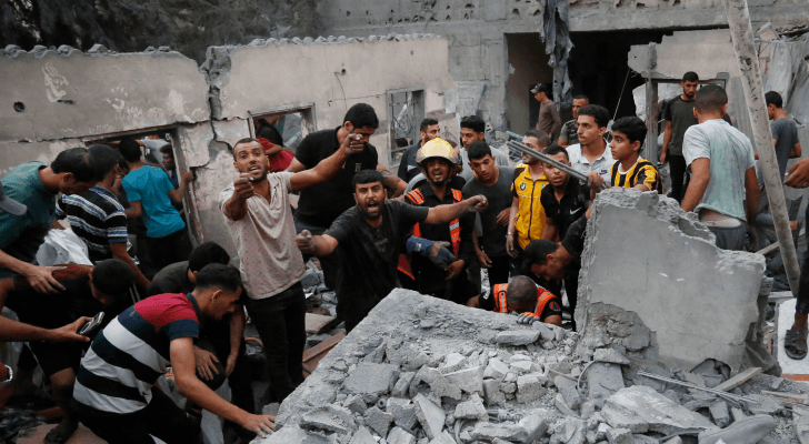 فلسطينيون يبحثون عن شهداء وناجين تحت أنقاض منزل تعرض للقصف في غزة