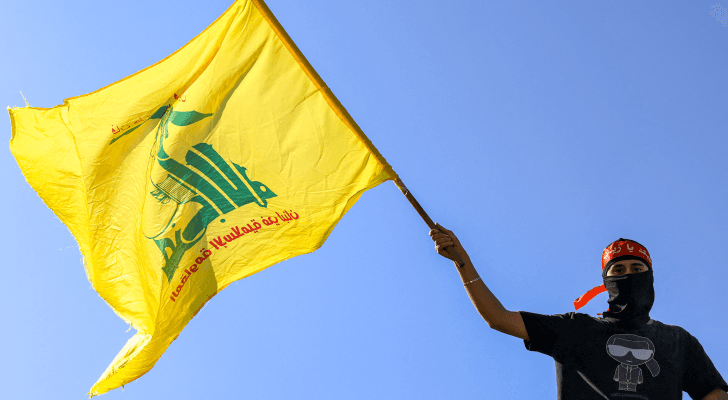 ملثم يحمل شعار المقاومة الإسلامية في لبنان "حزب الله"