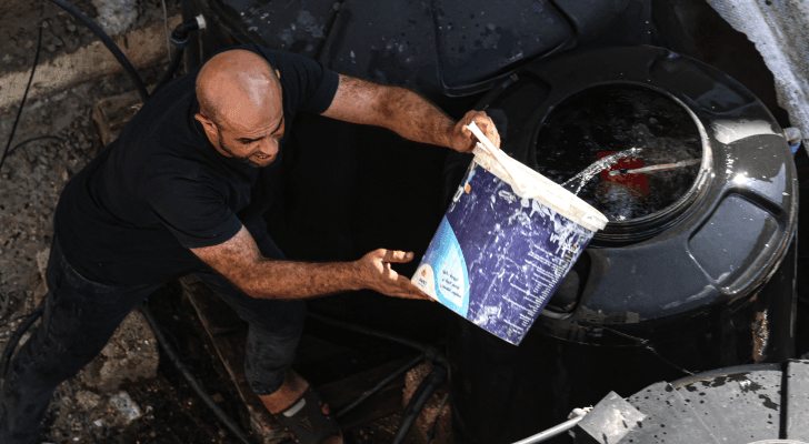 فلسطيني يعبئ خزان مياه في قطاع غزة