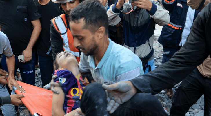 فلسطيني يحمل طفلة أصيبت جراء قصف الاحتلال الإسرائيلي