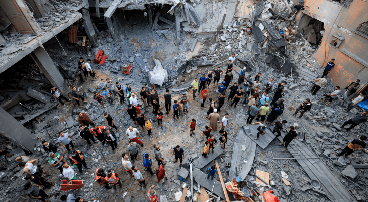 فلسطينيون يقفون عند ركام منزل دمره الاحتلال