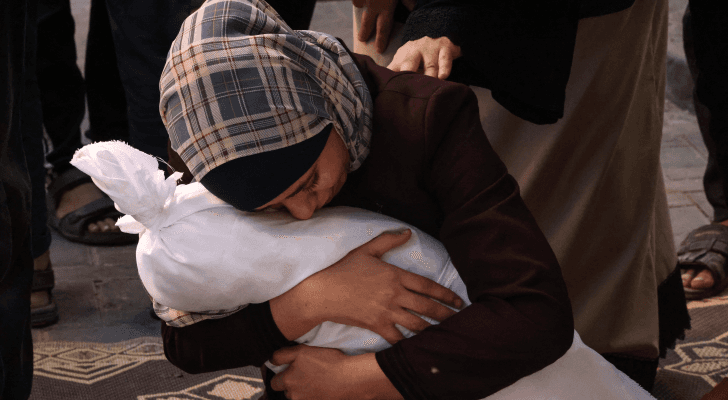 فلسطينية تحتضن طفلها الذي فقدته في قصف للاحتلال الإسرائيلي على قطاع غزة