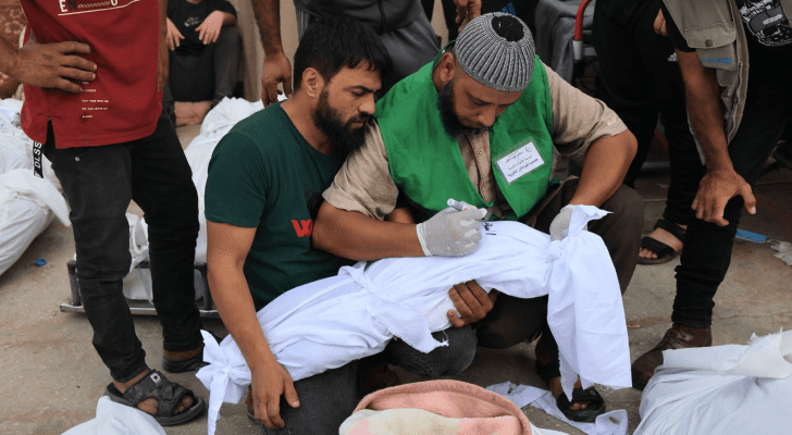 فلسطيني يكتب اسم الطفلة التي استشهدت بقصف على قطاع غزة