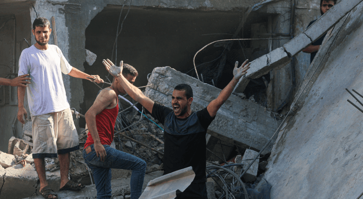 فلسطيني يقف بالقرب من أحد المنازل التي تعرضت لقصف الاحتلال