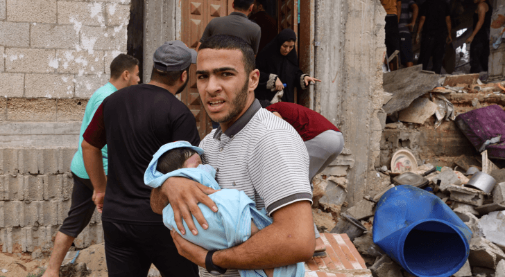 فلسطيني يحمل طفلة أصيبت جراء قصف الاحتلال الإسرائيلي