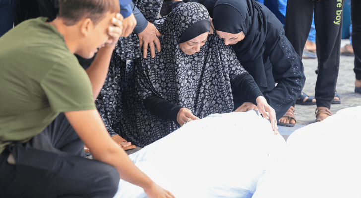 فلسطينيون يبكون أحد الشهداء الذي ارتقى بقصف الاحتلال لقطاع غزة