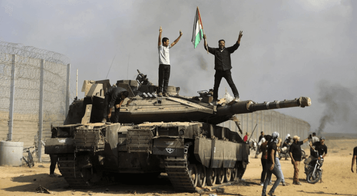 فلسطينيون يرفعون علم فلسطين على دبابة للاحتلال في معركة طوفان الأقصى