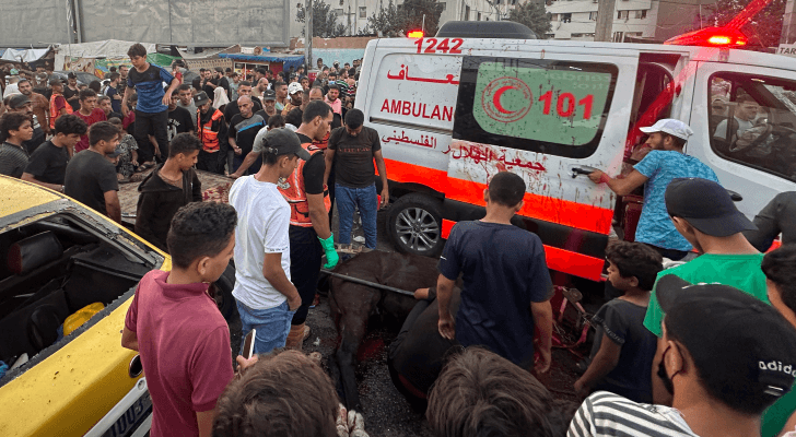فلسطينيون يتجمهرون حول مركبة إسعاف عقب قصفها من قبل الاحتلال الإسرائيلي