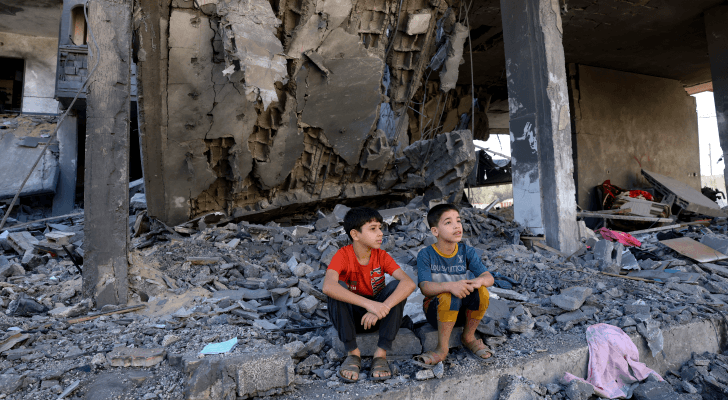 طفلان فلسطينيان يجلسان على أنقاض منزلهما بعد استهدافه من قوات الاحتلال الإسرائيلي